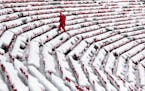 Daron Jones, University of Wisconsin's associate director of events and operations, trudges through the snow-covered west stands before an NCAA colleg