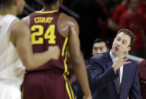 Minnesota coach Richard Pitino, right, gestures to forward Eric Curry during the first half of the team's NCAA college basketball game against Maryland, Wednesday, Feb. 22, 2017, in College Park, Md.