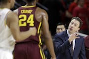 Minnesota coach Richard Pitino, right, gestures to forward Eric Curry during the first half of the team's NCAA college basketball game against Marylan