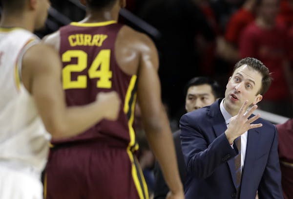 Minnesota coach Richard Pitino, right, gestures to forward Eric Curry during the first half of the team's NCAA college basketball game against Marylan