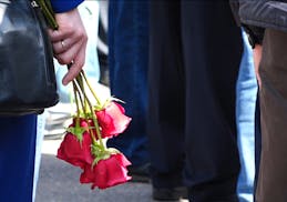 In this grab taken from a footage provided by the Russian State Atomic Energy Corporation ROSATOM press service, a woman holds roses as she and other 