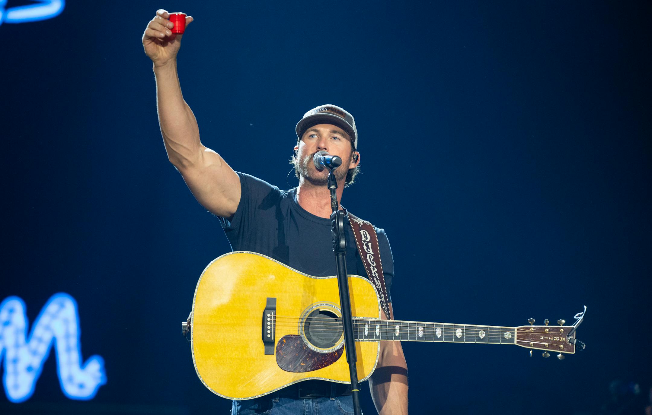 Riley Green takes a shot on stage while opening for Luke Combs at U.S. Bank Stadium.