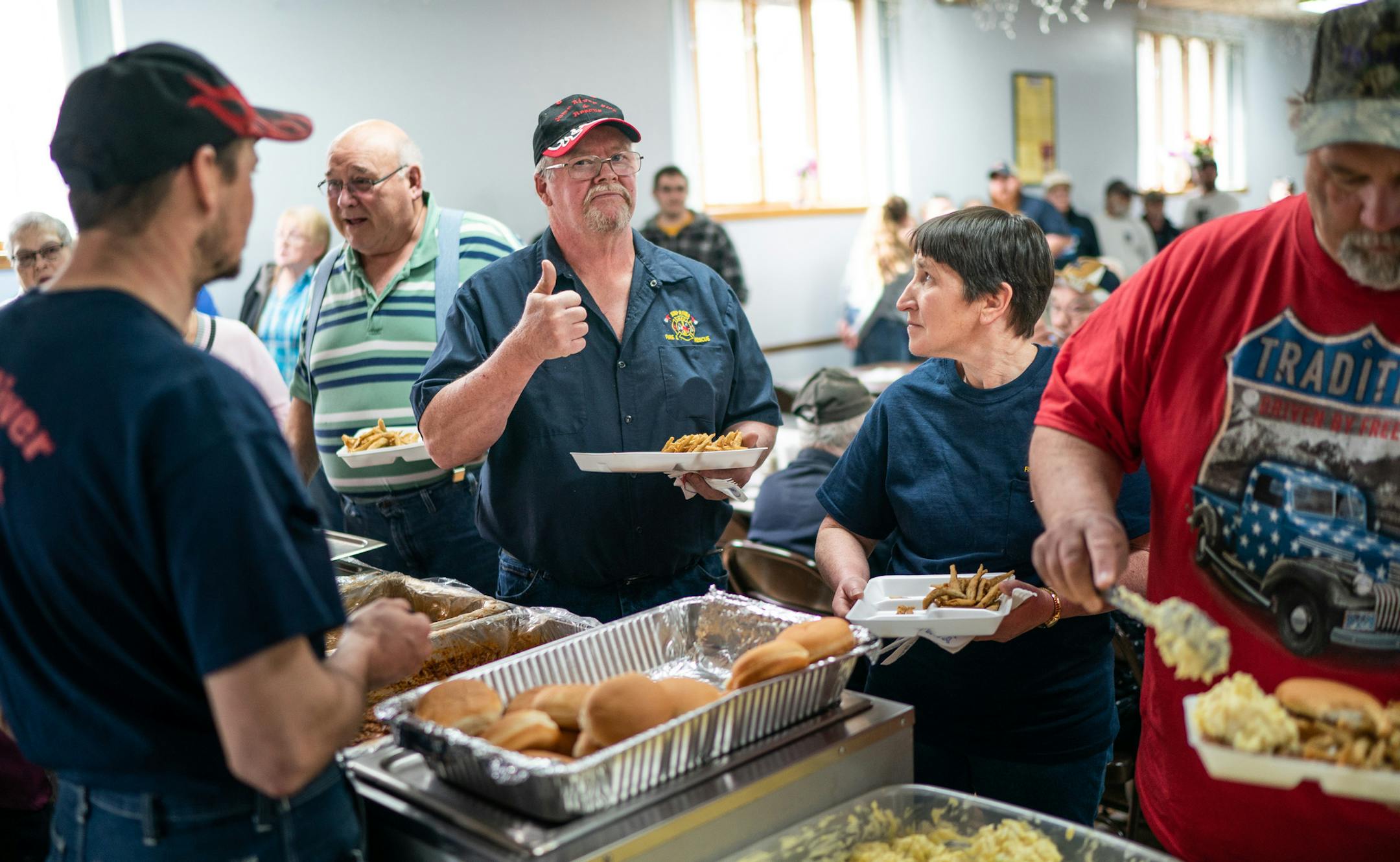 Bill Miller gave a thumbs-up to a fellow firefighter about the taste of the smelt at a fundraiser for the Jump River Volunteer Fire Department. Wisconsin's Taylor County is a rural county with a low unemployment rate and a deep-red voting tradition.