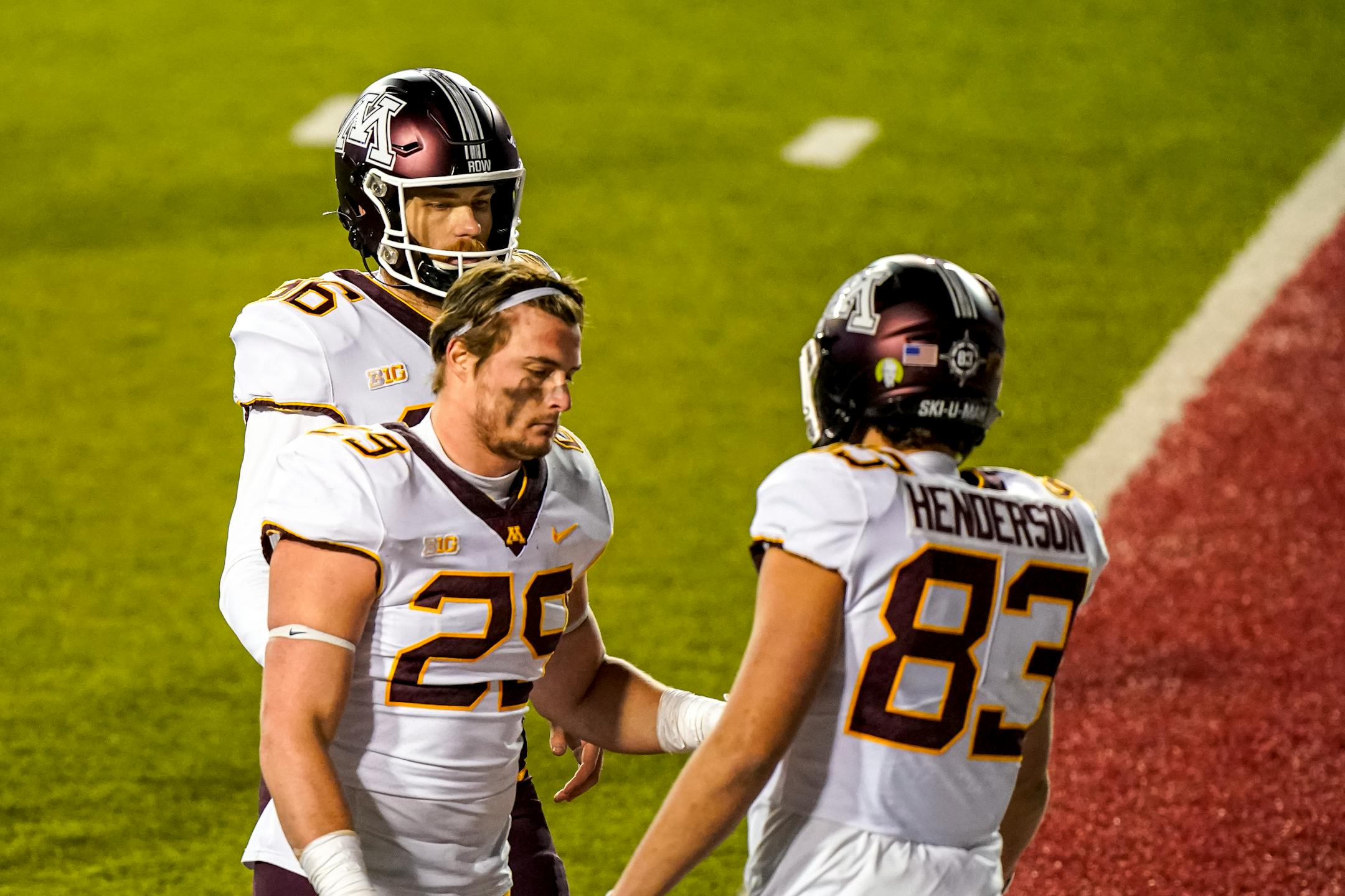 Minnesota's Josh Aune (29) and Austin Henderson walk off the field after Wisconsin defeated them in overtime on Saturday. The Gophers finished the regular season 3-4