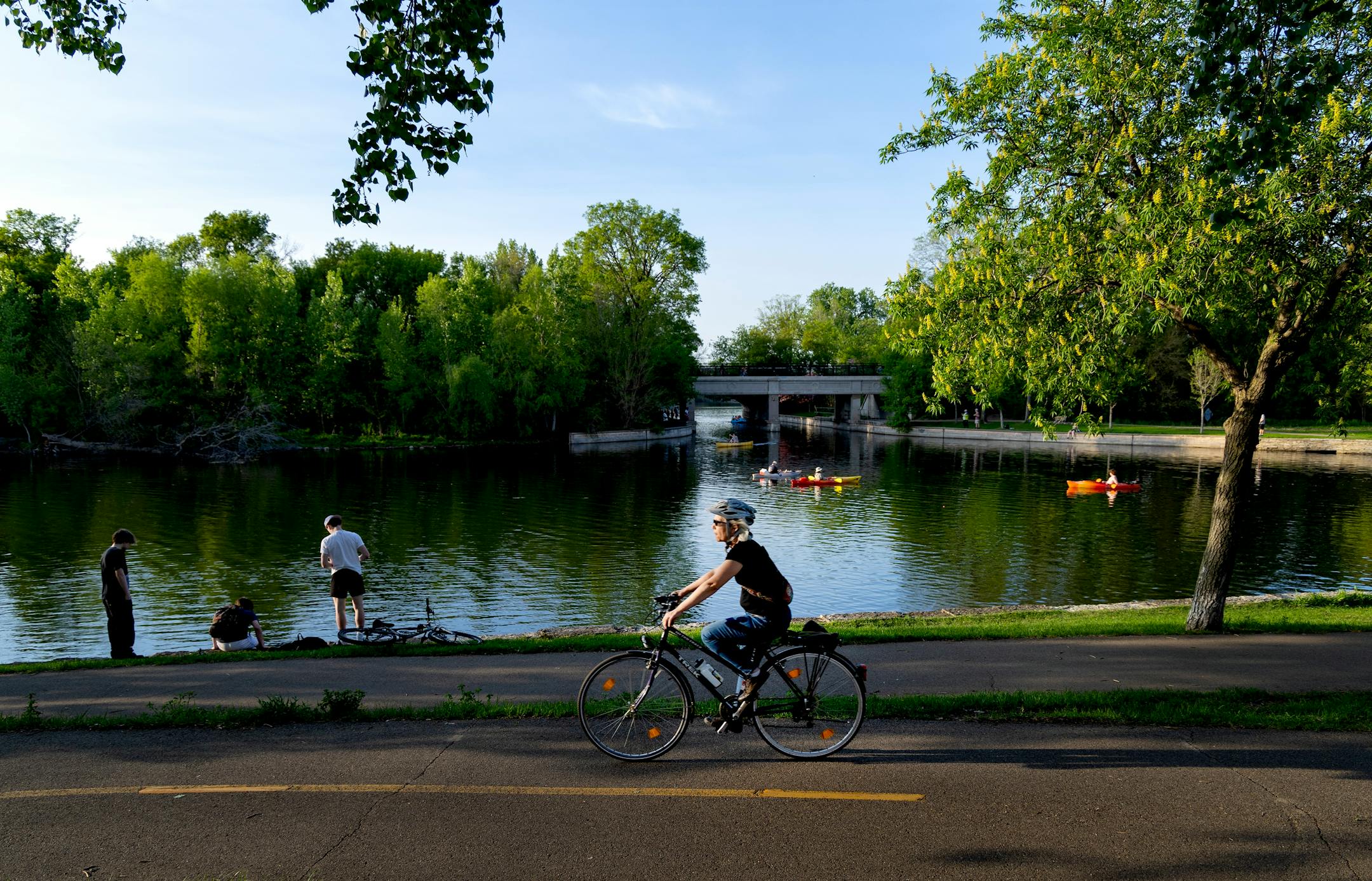 Photo of a woman riding a bicycle in front of a lake