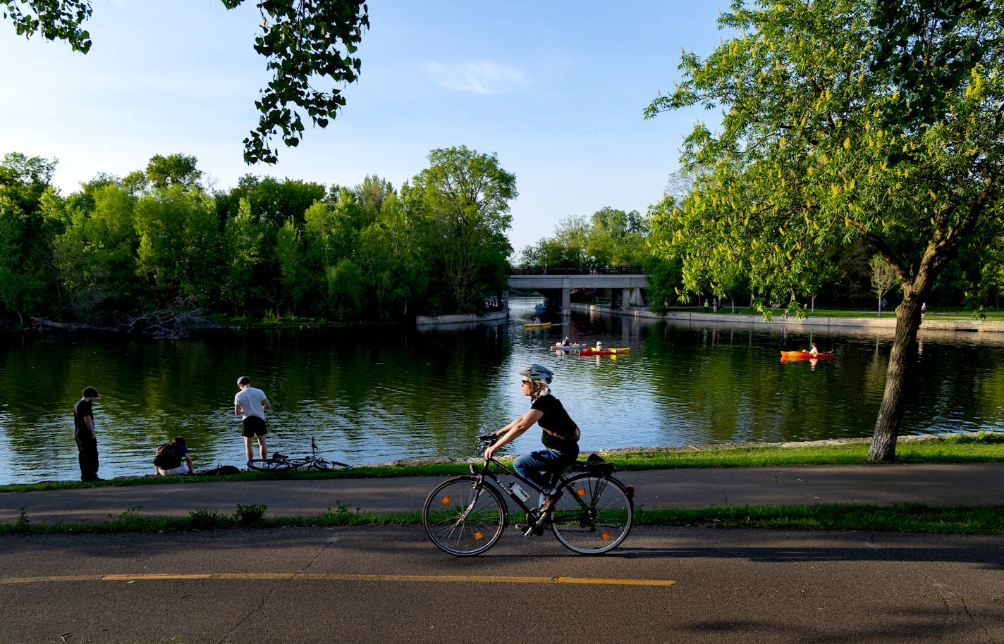 Photo of a woman riding a bicycle in front of a lake