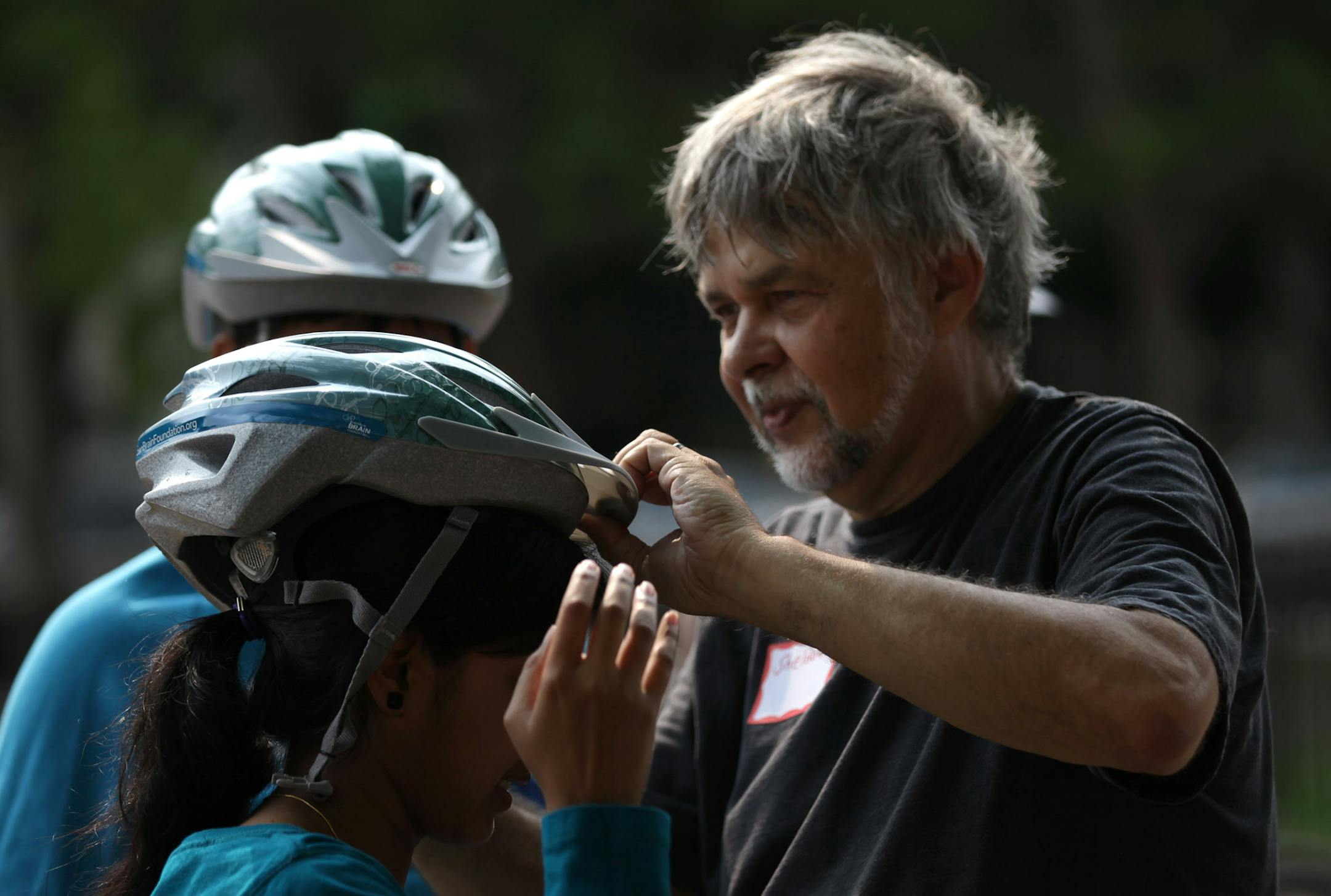 Instructor Sheldon Mains adjusted Sruthi Reddy's helmet at a Learn-to-Ride session at Matthews Park in July.