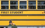 Kids watch a police officer investigate their school bus that collided with another bus on January 26, 2017, in Wichita, Kan.; according to police, 27