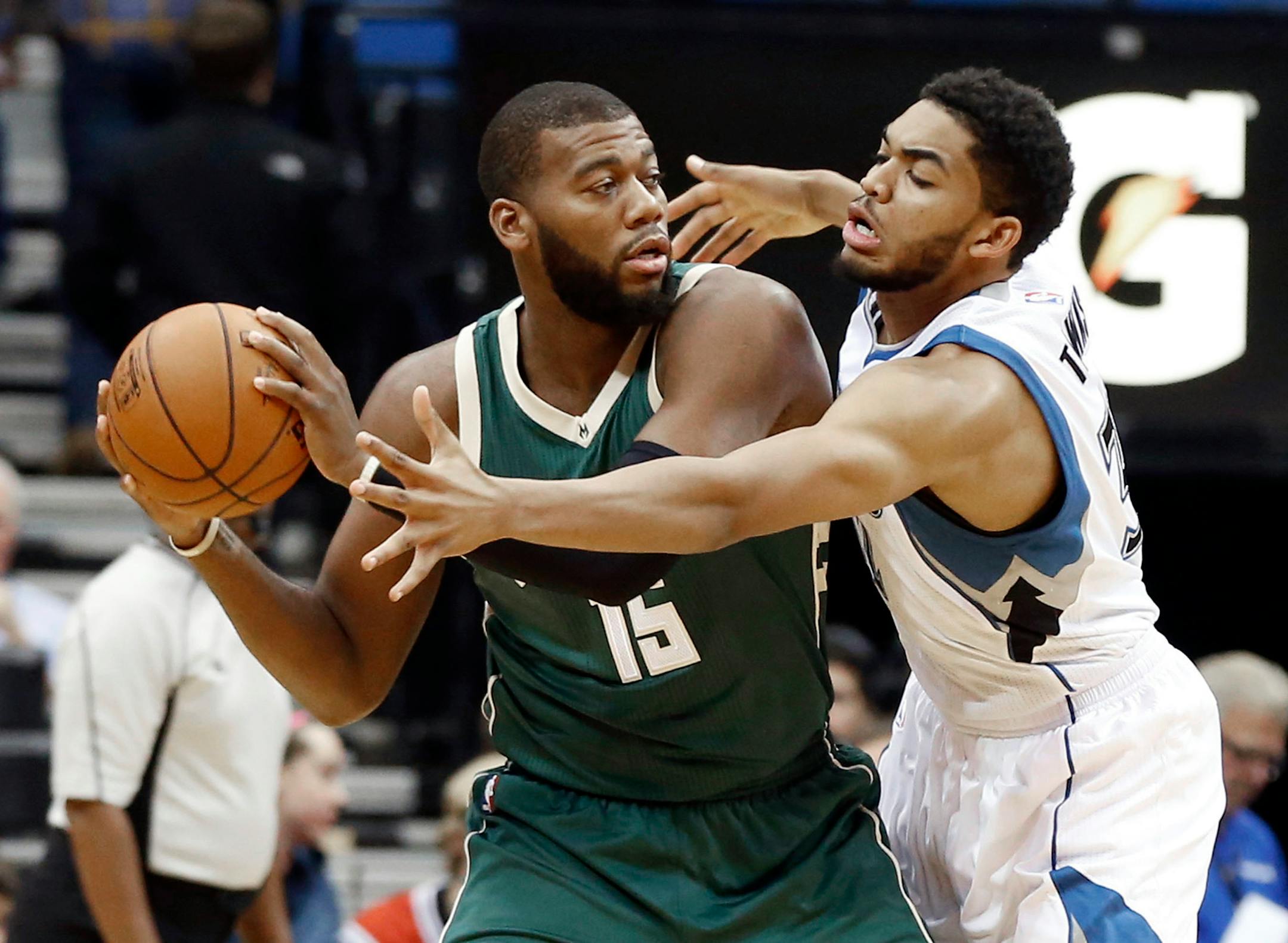 Karl-Anthony Towns, right, tries to get to the ball held by Milwaukee Bucks' Greg Monroe in the first half of an NBA preseason game, Friday, Oct. 23, 2015, in Minneapolis. (AP Photo/Jim Mone)