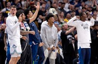 Timberwolves players react to a fourth-quarter basket by Rudy Gobert that helped defeat the Nuggets.