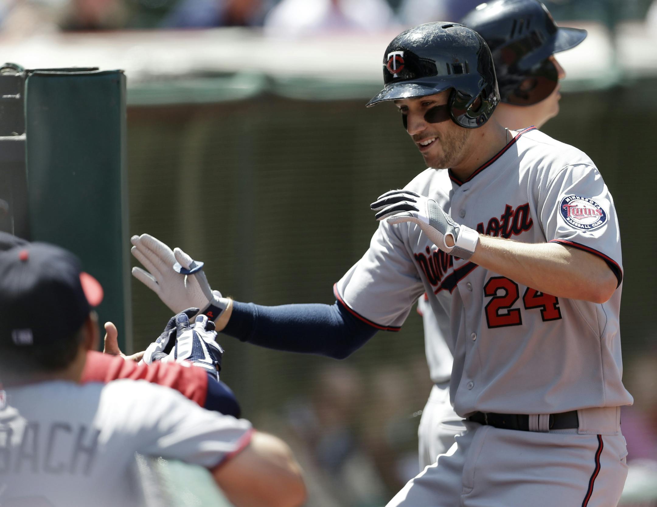 Minnesota Twins' Trevor Plouffe is congratulated by teammates after hitting a two-run home run off Cleveland Indians starting pitcher Corey Kluber in the second inning of a baseball game on Sunday, May 5, 2013, in Cleveland. Chris Parmelee also scored. (AP Photo/Tony Dejak)
