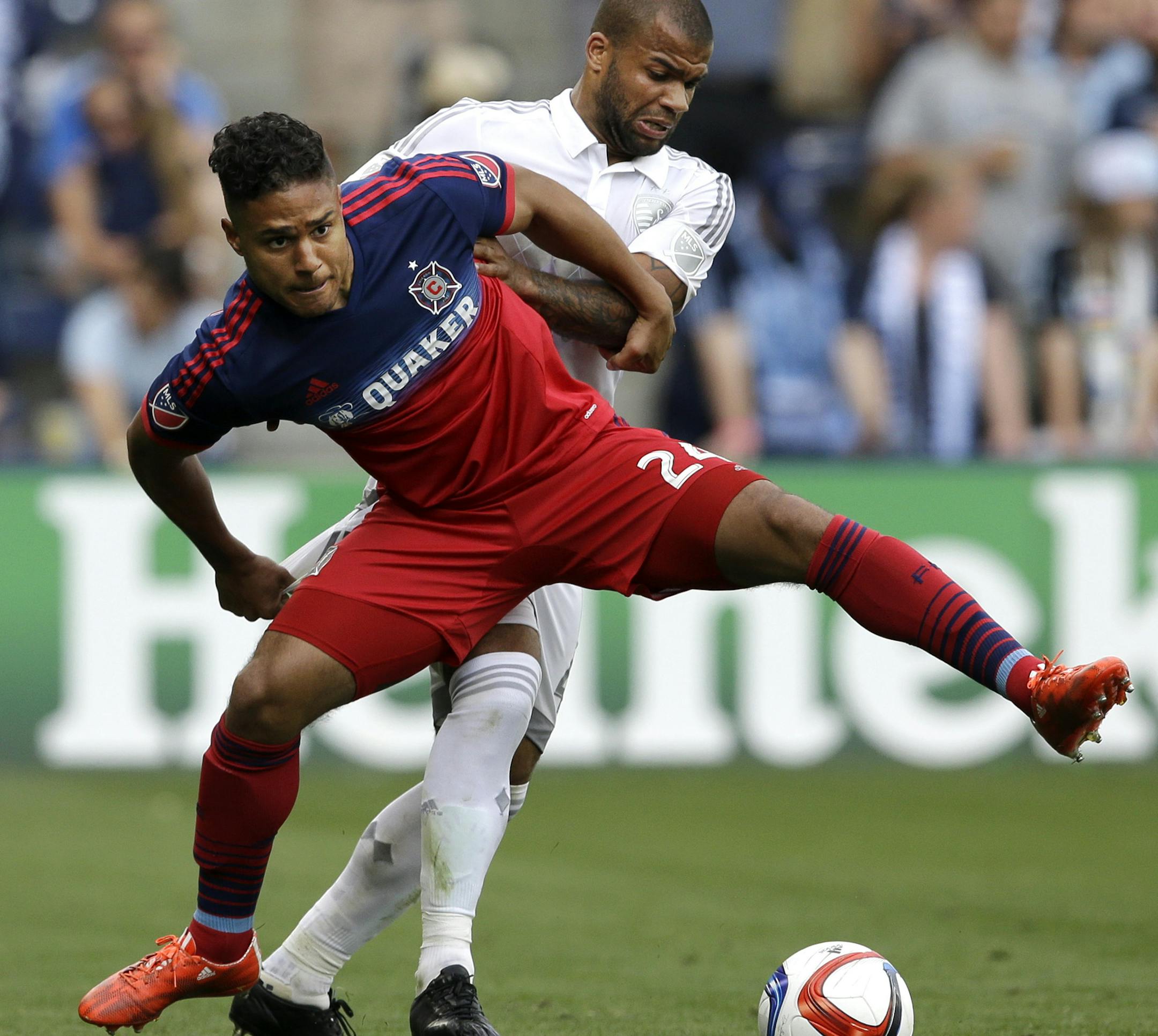 Chicago Fire forward Quincy Amarikwa (24) gets a lift from Sporting KC defender Kevin Ellis, back, during the second half of an MLS soccer match in Kansas City, Kan., Sunday, May 3, 2015. (AP Photo/Orlin Wagner) ORG XMIT: KSOW101