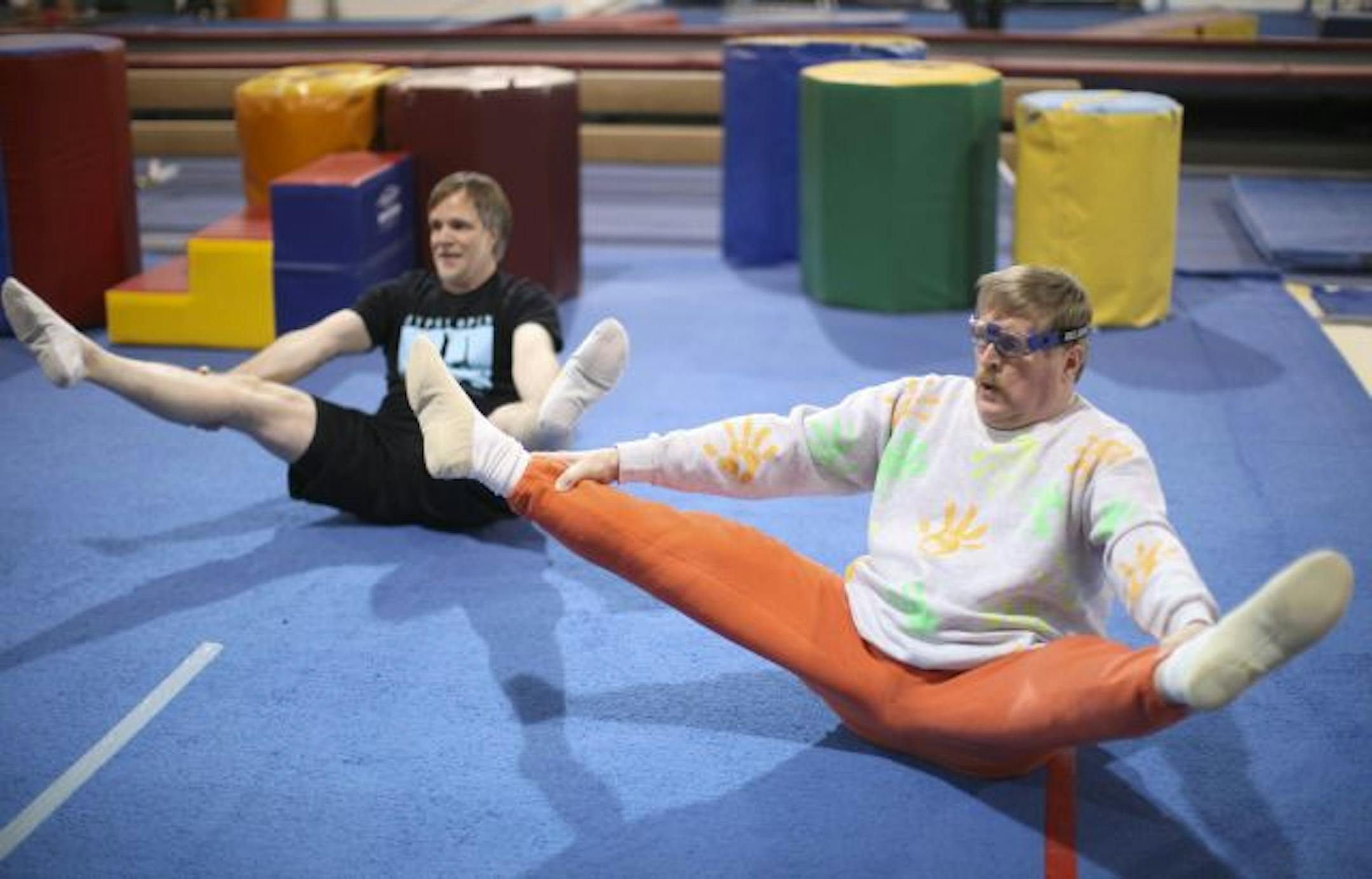 Jim Grindeland, left, and Paul Armour stretched at the start of their adult gymnastics class at Gleason's Gymnastics School.