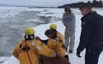 Rescuers tend to a woman pulled from Lake Superior.