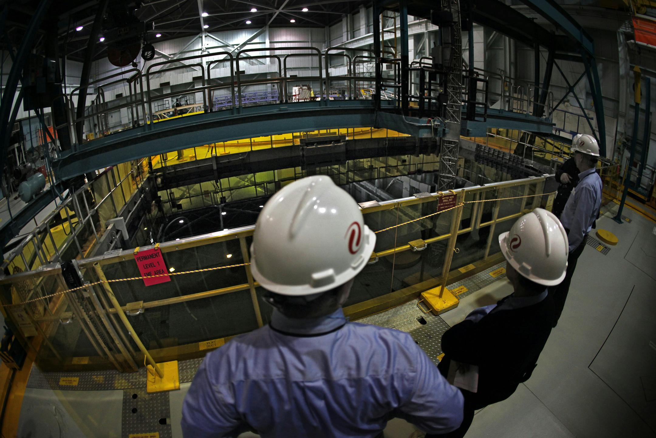 Xcel Energy officials and others examine the 38-foot-deep pool which holds spent fuel rods taken out of the reactor. The rods, covered by 24 feet of water, simmer for about a decade before they are moved to casks that are stored outdoors. Cranes above the pool help move the assemblies of fuel rods. ] JIM GEHRZ‚Ä¢jgehrz@startribune.com (JIM GEHRZ/STAR TRIBUNE) / February 28, 2012 / 9:00 AM , Monticello, MN** BACKGROUND INFORMATION: The Monticello Nuclear Generating Plant is opera