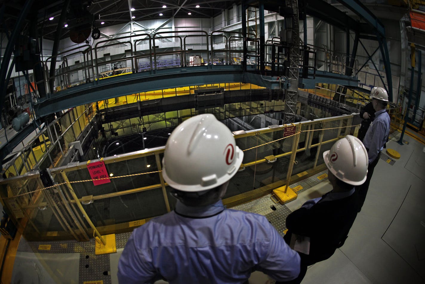 Xcel Energy officials and others examine the 38-foot-deep pool which holds spent fuel rods taken out of the reactor. The rods, covered by 24 feet of water, simmer for about a decade before they are moved to casks that are stored outdoors. Cranes above the pool help move the assemblies of fuel rods. ] JIM GEHRZ&#x201a;&#xc4;&#xa2;jgehrz@startribune.com (JIM GEHRZ/STAR TRIBUNE) / February 28, 2012 / 9:00 AM , Monticello, MN** BACKGROUND INFORMATION: The Monticello Nuclear Generating Plant is opera