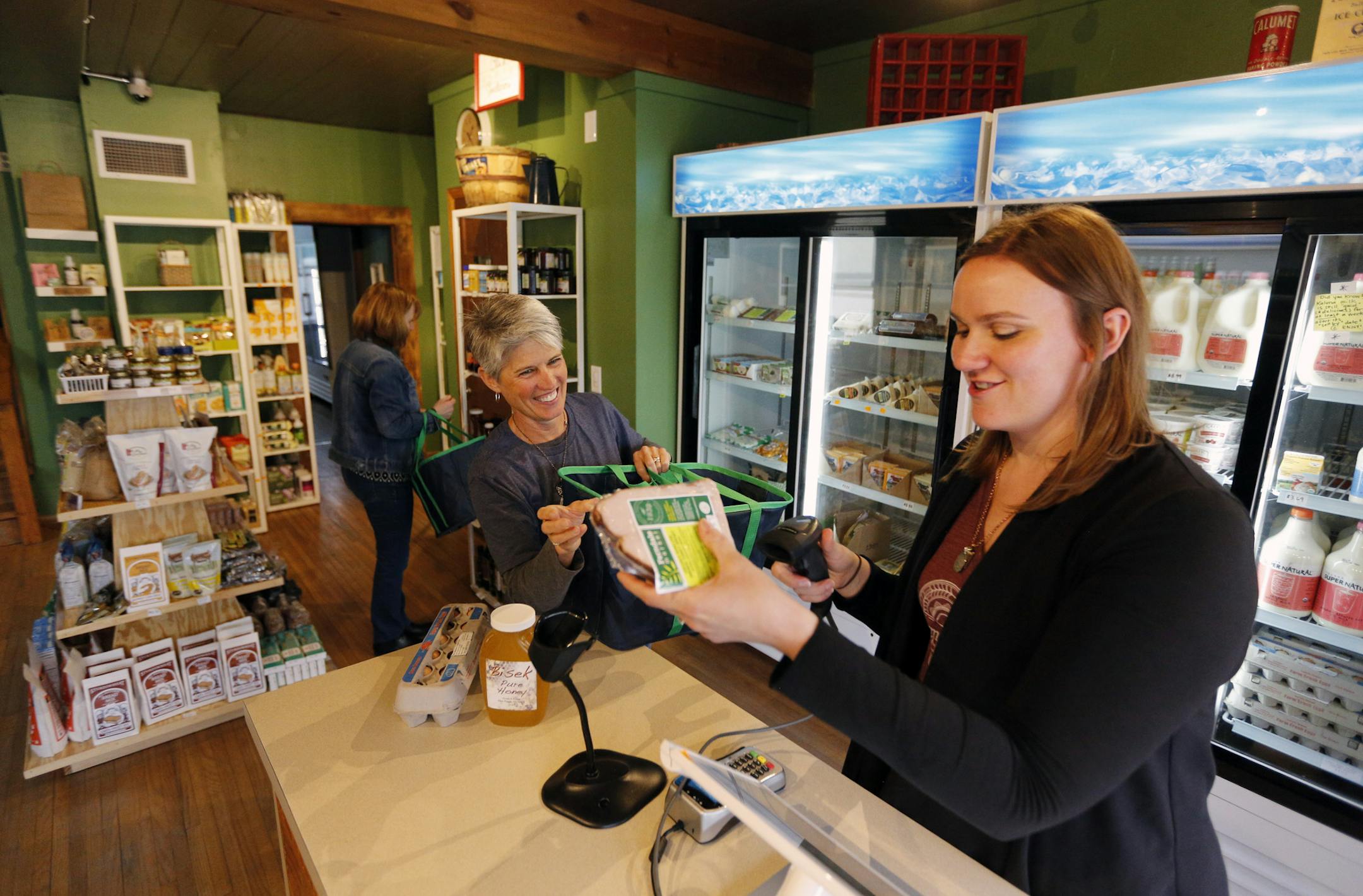 Farmhouse Market sells memberships, and members can enter 24 hours a day and buy what they want, using a tablet to check out when the store is unstaffed. Here, co-owner Kendra Rasmusson, right, tended to member Carrie DeValk.