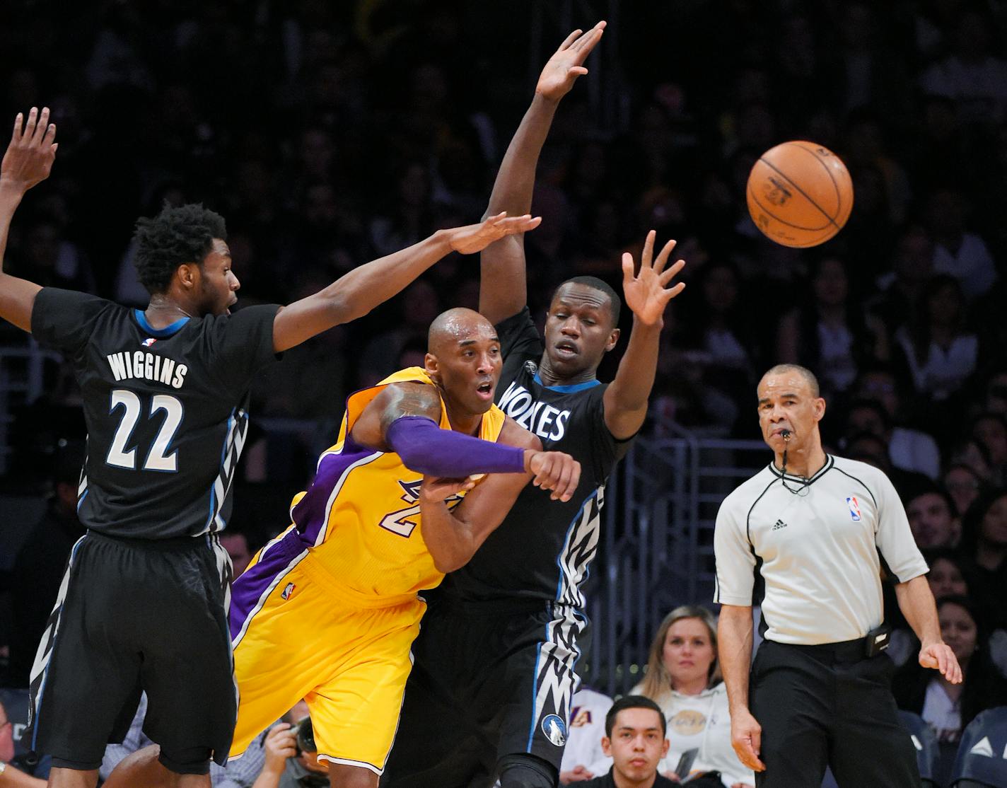 Los Angeles Lakers forward Kobe Bryant, second from left, passes the ball as Minnesota Timberwolves guard Andrew Wiggins, left, and center Gorgui Dieng defend during the first half of an NBA basketball game Tuesday, Feb. 2, 2016, in Los Angeles. (AP Photo/Mark J. Terrill)