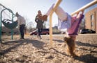 Catherine, left, and Julianna Sheridan play with their two kids at a playground. The couple are fighting to keep sole custody of their 5-year-old daug