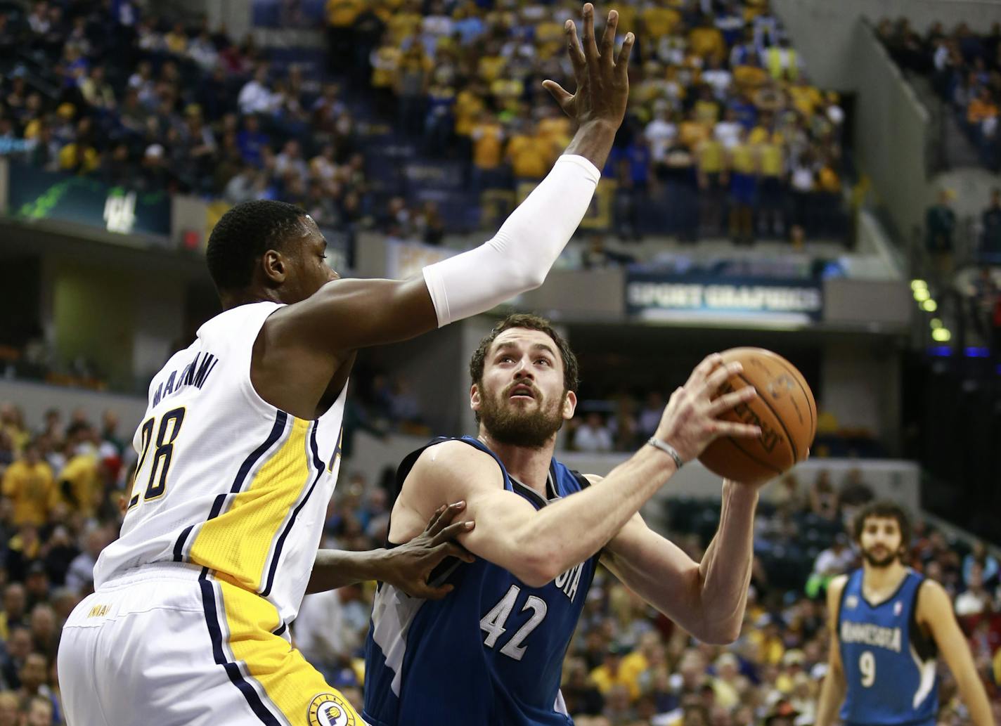 Minnesota Timberwolves forward Kevin Love (42) moves with the ball near the basket as Indiana Pacers center Ian Mahinmi defends during the first half of an NBA basketball game in Indianapolis, Monday, Nov. 25, 2013. (AP Photo/R Brent Smith)