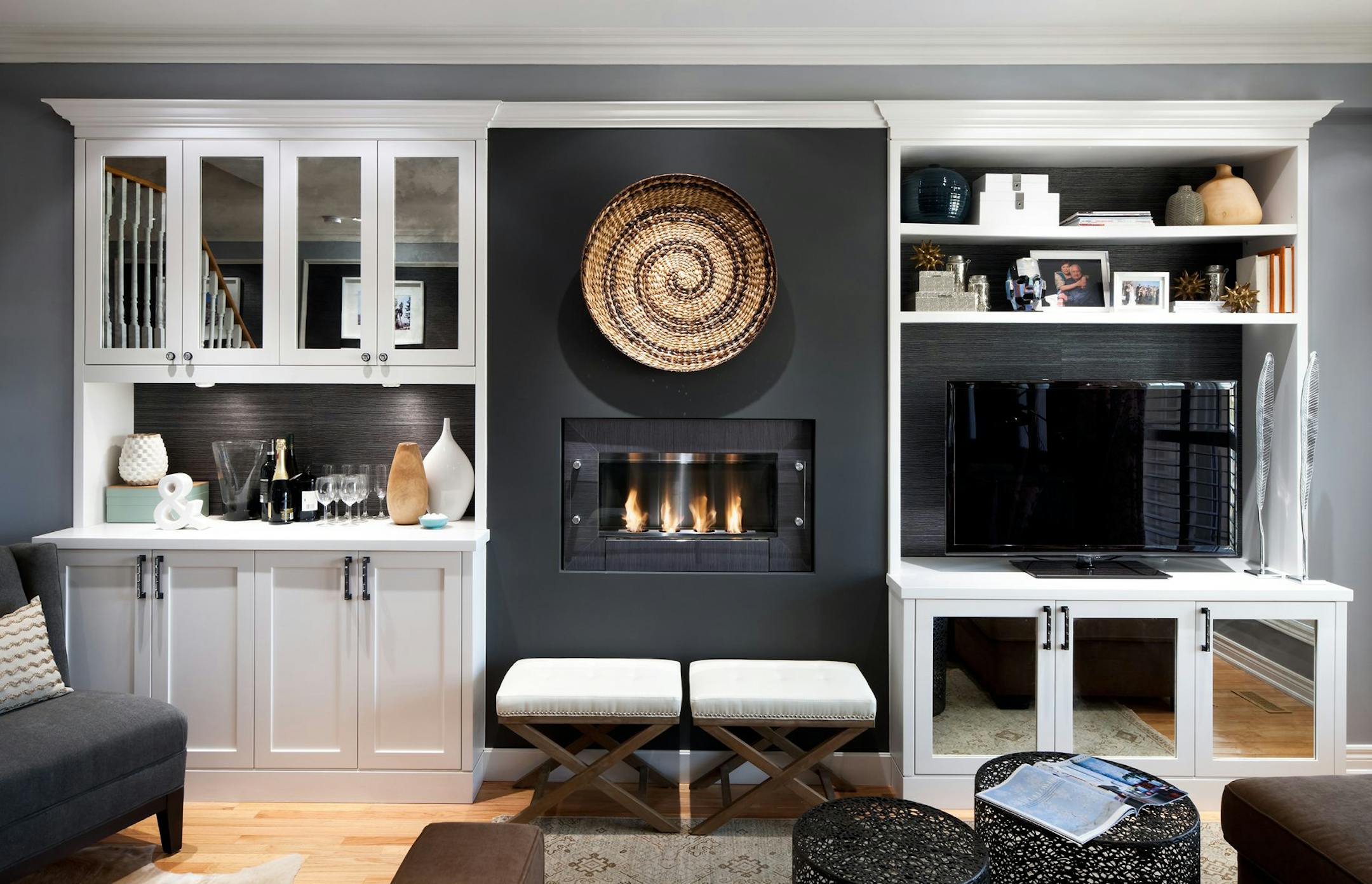 Working down the room's longest wall, a gorgeous ethanol fireplace was installed beside the TV. It was finished up with more custom cabinetry housing a bar. The cabinets feature open shelving to show off pretty pieces, and antique mirrored glass doors to hide the things that aren't nice enough to display. (Brandon Barre/MCT) ORG XMIT: 1148957