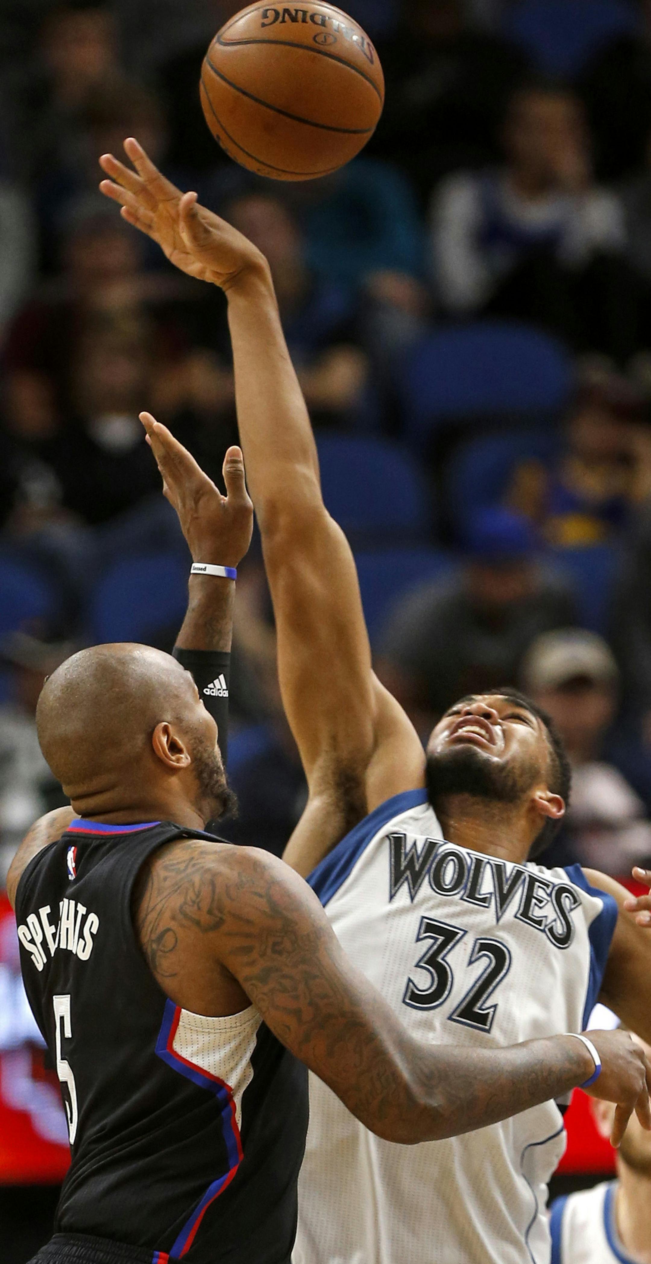 Minnesota Timberwolves center Karl-Anthony Towns (32) tips away the ball from Los Angeles Clippers center Marreese Speights (5) in the first half of an NBA basketball game Saturday, Nov. 12, 2016, in Minneapolis. (AP Photo/Bruce Kluckhohn)