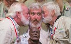 In this Saturday, July 23, 2016 photo provided by the Florida Keys News Bureau, Dave Hemingway, center, receives smooches from Charlie Boise, left, an
