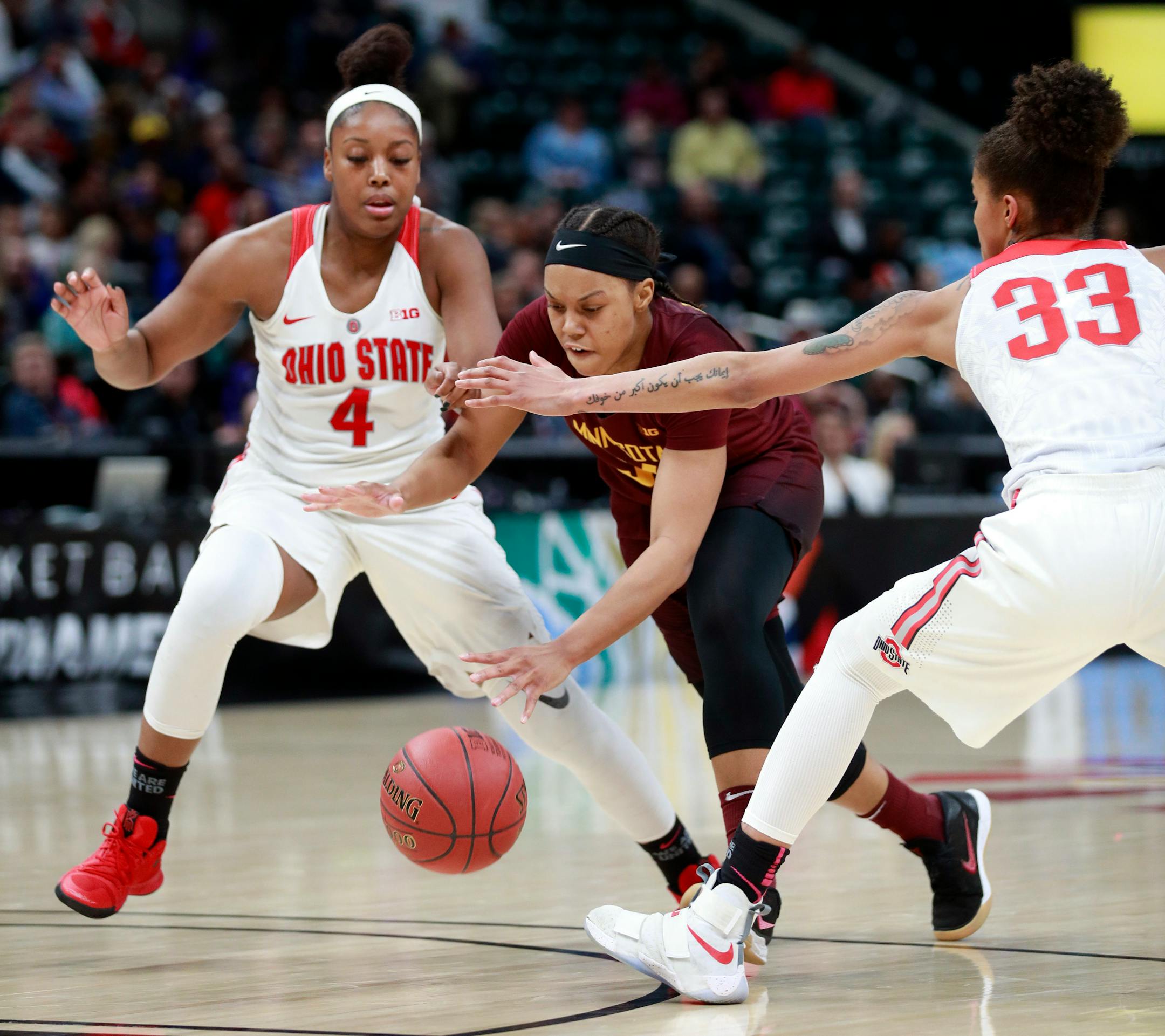 Minnesota guard Gadiva Hubbard dribbles between Ohio State guards Jensen Caretti (33) and Sierra Calhoun during the first half of an NCAA college basketball game in the semifinals of the Big Ten women's tournament Saturday.