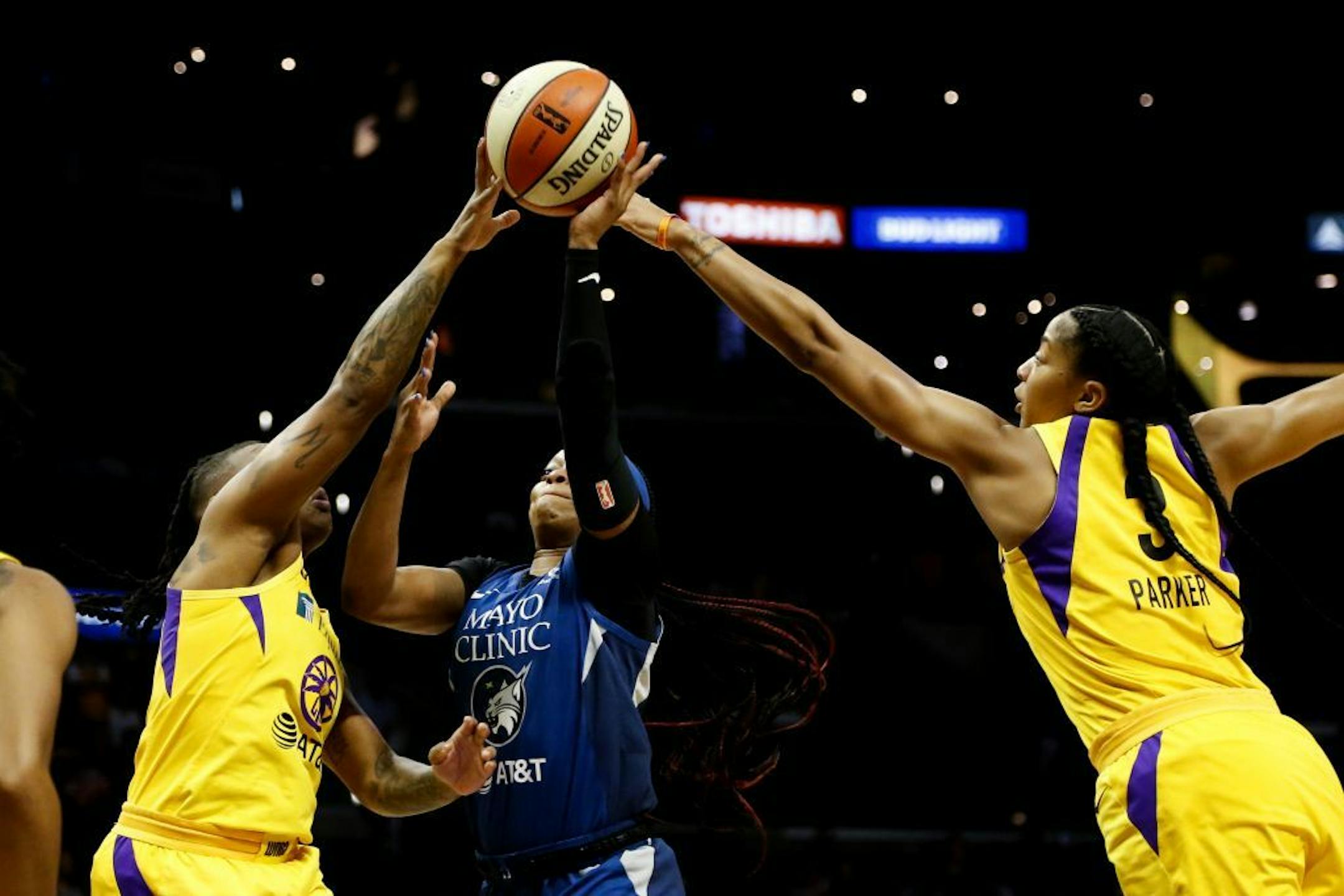Minnesota Lynx's Odyssey Sims, center, goes up to basket while defended by Los Angeles Sparks' Candace Parker, right, and Riquna Williams during the first half of a WNBA basketball game in Los Angeles, Sunday, Sept. 8, 2019.