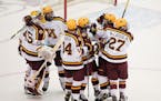 Minnesota defenseman Ryan Johnson (23) was mobbed by his teammates after he scored from down the ice on an empty net in the third period. ] ANTHONY SO