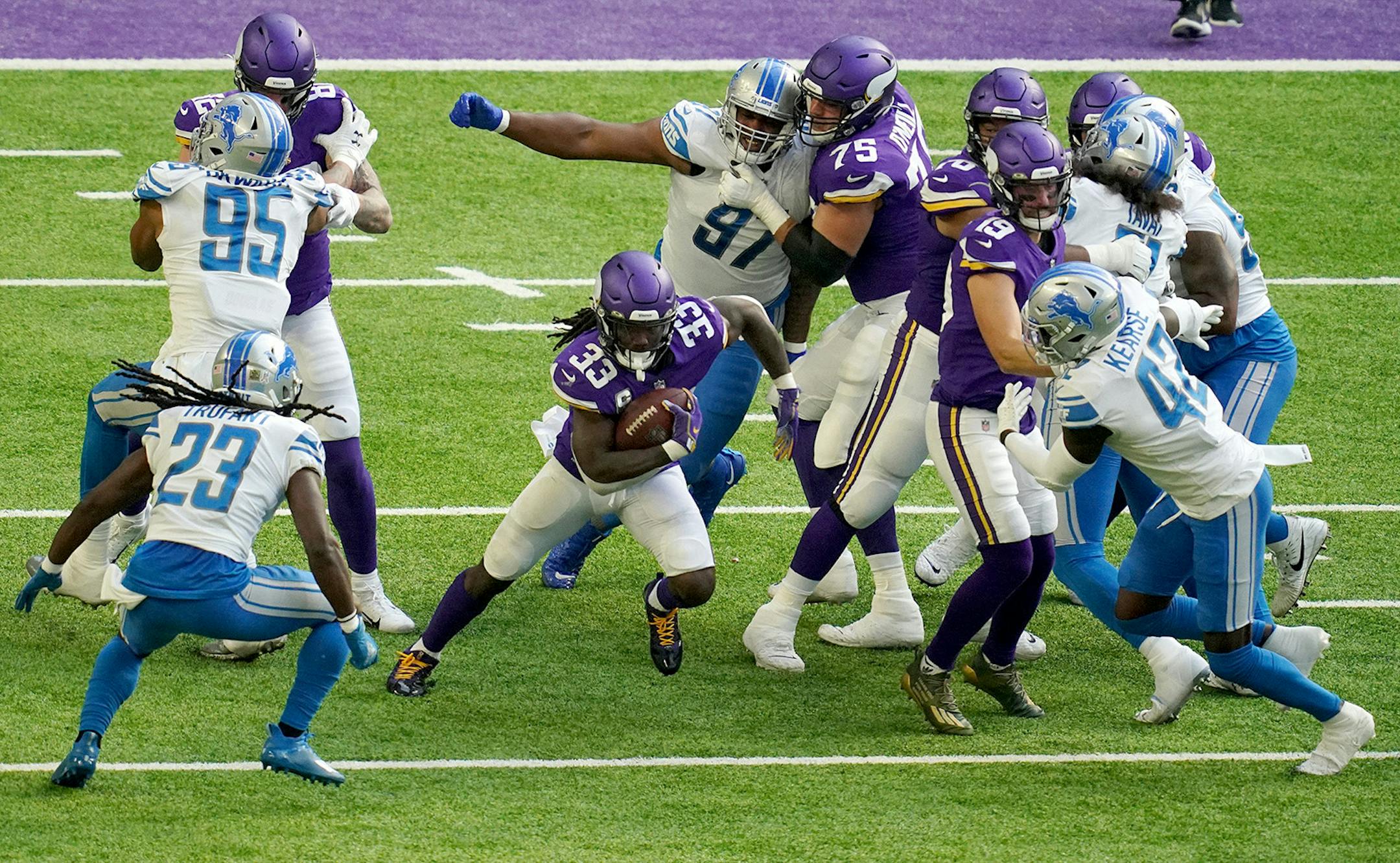 Minnesota Vikings running back Dalvin Cook (33) cut through the Detroit Lions defense as he rushed the ball in the second quarter.