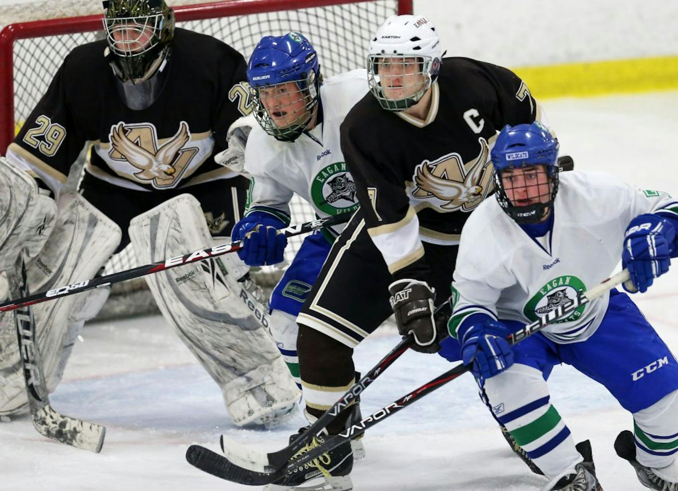 Apple Valley goalie Mac Wartick waited for a shot as Eagles captain Christian Smith battled a pair of Eagan players during Tuesday night's game. Richard Tsong-Taatarii • rtsongtaatarii@startribune.com