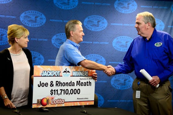 Minnesota Lottery director Ed Van Petten, right, presented Bethel couple Joe and Rhonda Meath as multi-million dollar lotto winners in September.