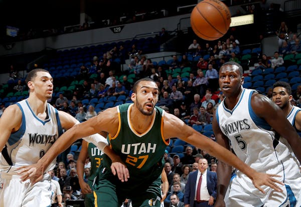 The Wolves' Zach LaVine (8) and Gorgui Dieng (5) battled the Jazz's Rudy Gobert (27) for a loose ball in the first quarter Monday night. ] CARLOS GONZ