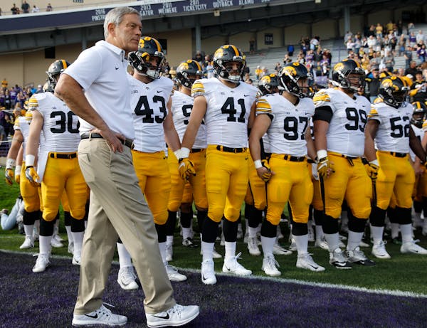 Iowa coach Kirk Ferentz with his team before going onto the field against Northwestern