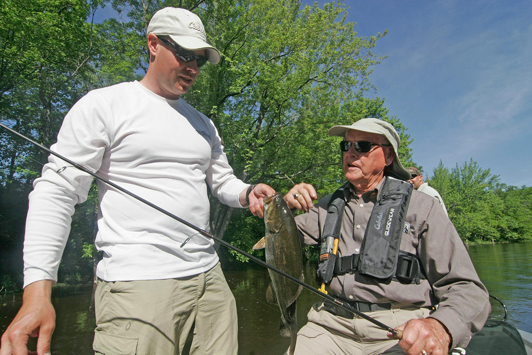 Nate Foster (left), 35, of St. Cloud, a veteran of the wars in Afganistan and Iraq, and his grandfather, Swede Anderson, 82, of Rochester, a veteran of the Korean War, holds a smallmouth bass Anderson caught during the Trolling for the Troops event Friday at Camp Ripley.