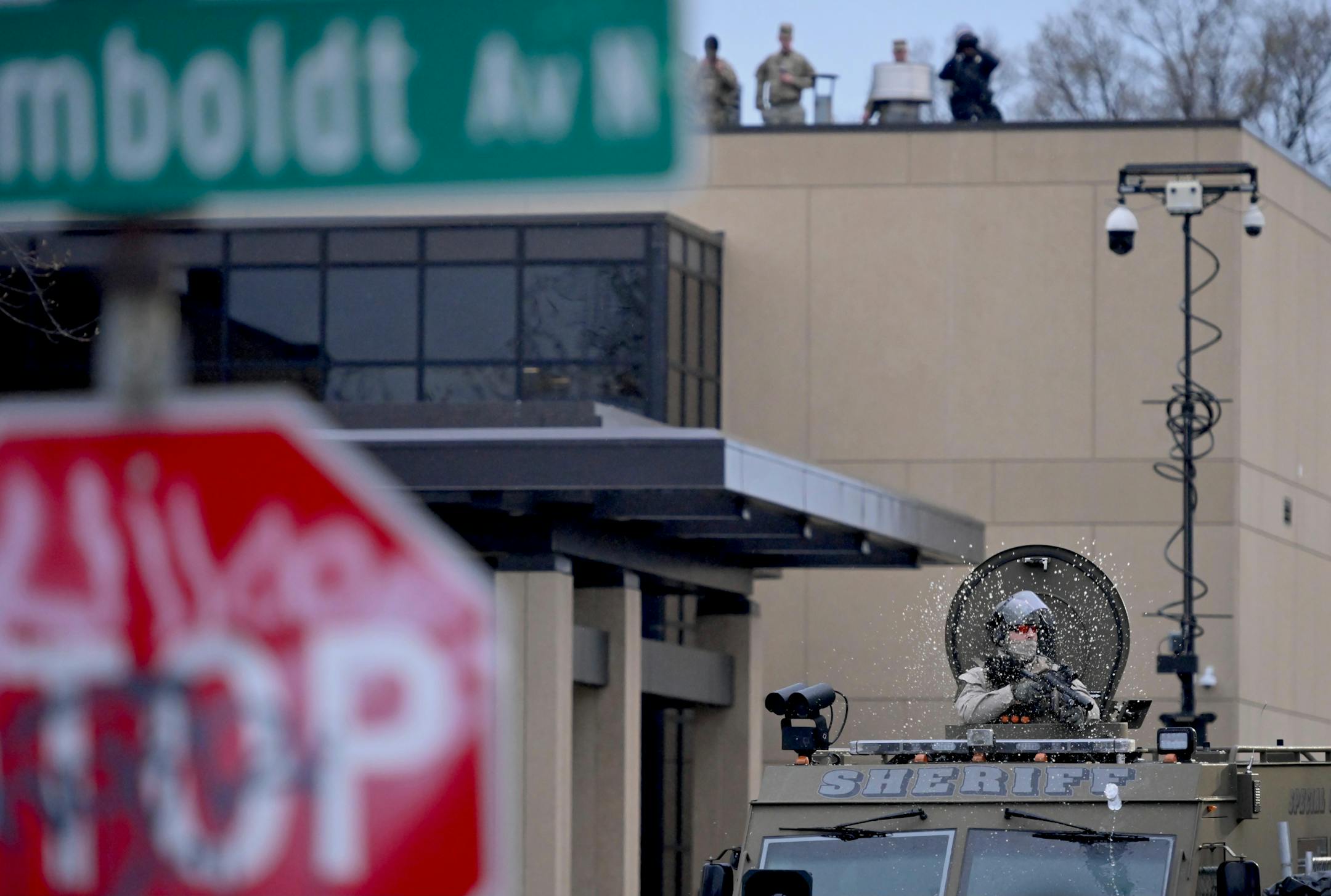 A law enforcement officer is pelted with a water bottle as people protest near the Brooklyn Center Police Department in response to the fatal police shooting of Daunte Wright, Wednesday, April 14, 2021 in Brooklyn Center, Minn.