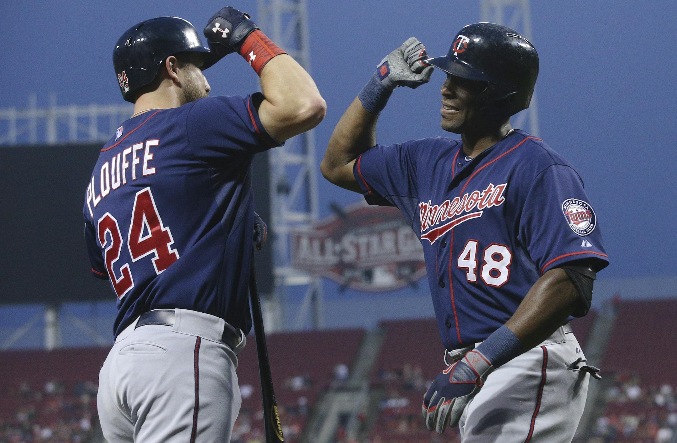 Minnesota Twins' Torii Hunter (48) celebrates with Trevor Plouffe (24) after hitting a solo home run off Cincinnati Reds starting pitcher Anthony DeSclafani in the first inning of a baseball game, Tuesday, June 30, 2015, in Cincinnati. (AP Photo/John Minchillo)