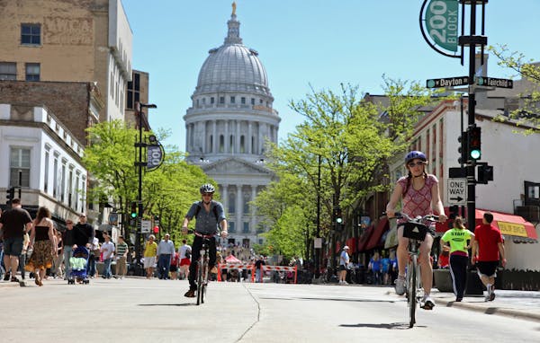This undated image provided by the Greater Madison Convention & Visitors Bureau shows bicyclists on State Street in Madison, Wis. State Street runs ab