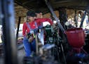 Jen Roth, front, of Sartell, and Nicole Wallace, of Detroit Lakes, performed some maintenance on a 28-horsepower Minneapolis Steam Traction Engine pro