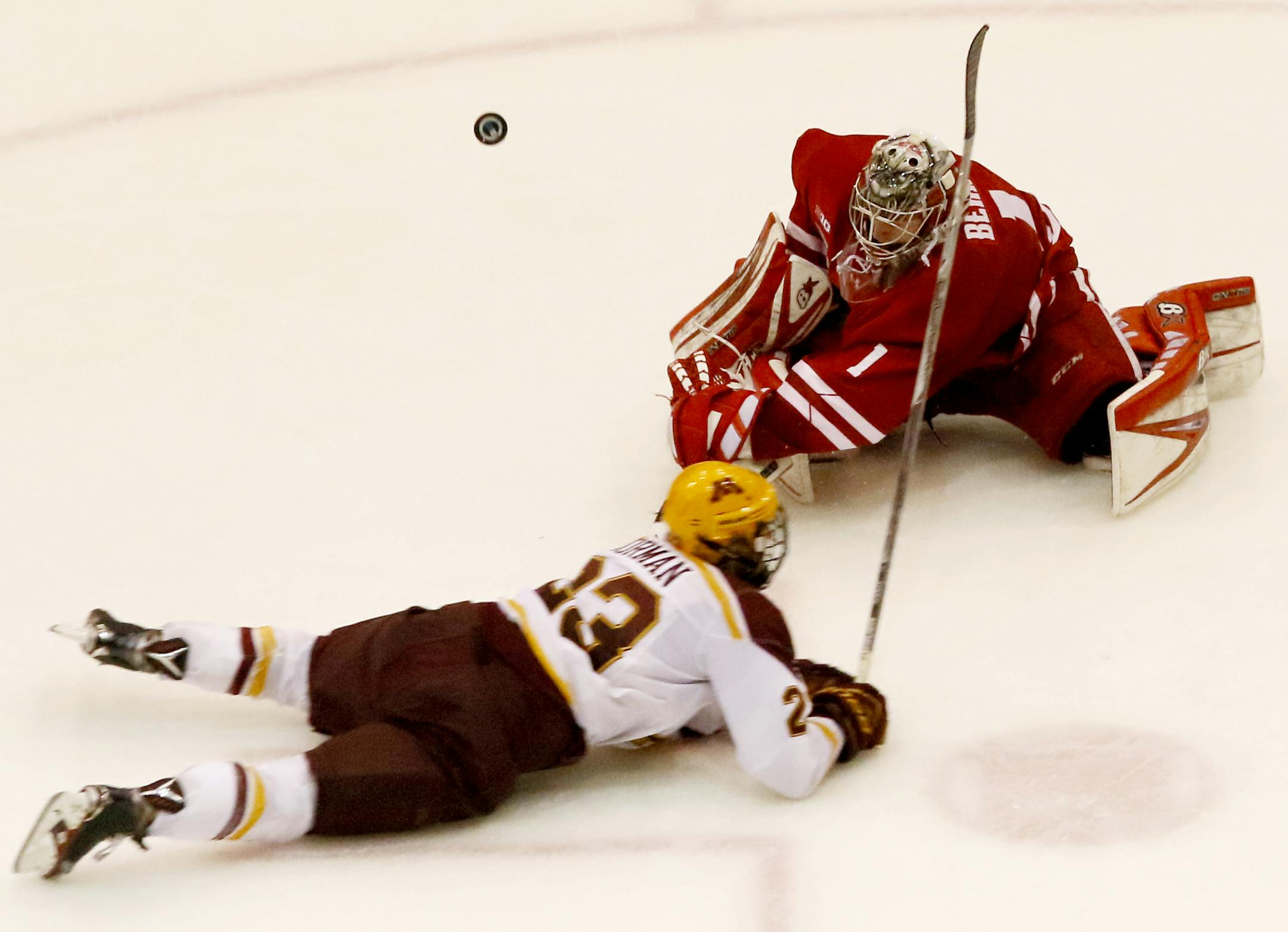 Minnesota's Ryan Norman (23) dives to the ice after attempting a last ditch score when Wisconsin's Jack Berry (1) was away from the goal. ] MATT WEBER •