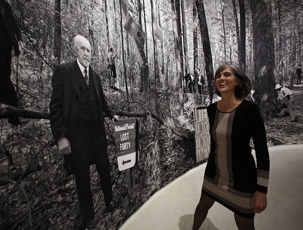Walker director Olga Viso struck a pose with the center's founder, lumber baron T.B. Walker, as depicted in "Lost Forty," a 2011 tapestry by Goshka Ma