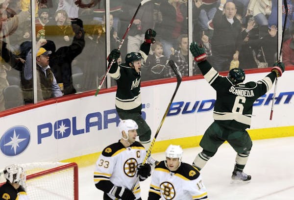 Wild forward Chad Rau (back) celebrated after slipping a nifty wrist shot past Bruins goalie Tim Thomas to open the scoring in Minnesota's 2-0 victory