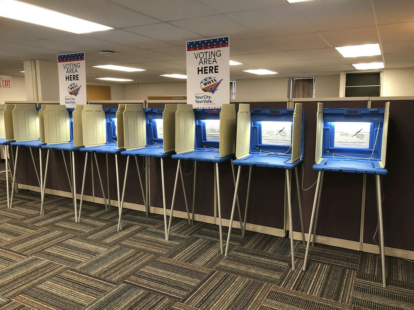 In this Sept. 20, 2018 photo, voting booths stand ready in downtown Minneapolis for the opening of early voting in Minnesota. Election officials and federal cybersecurity agents are touting improved collaboration aimed at confronting and deterring efforts to tamper with elections. Granted, the only way to go was up: In 2016 amid Russian meddling, federal officials were accused first of being too tight-lipped on intelligence about possible hacking into state systems, and later criticized for tryi