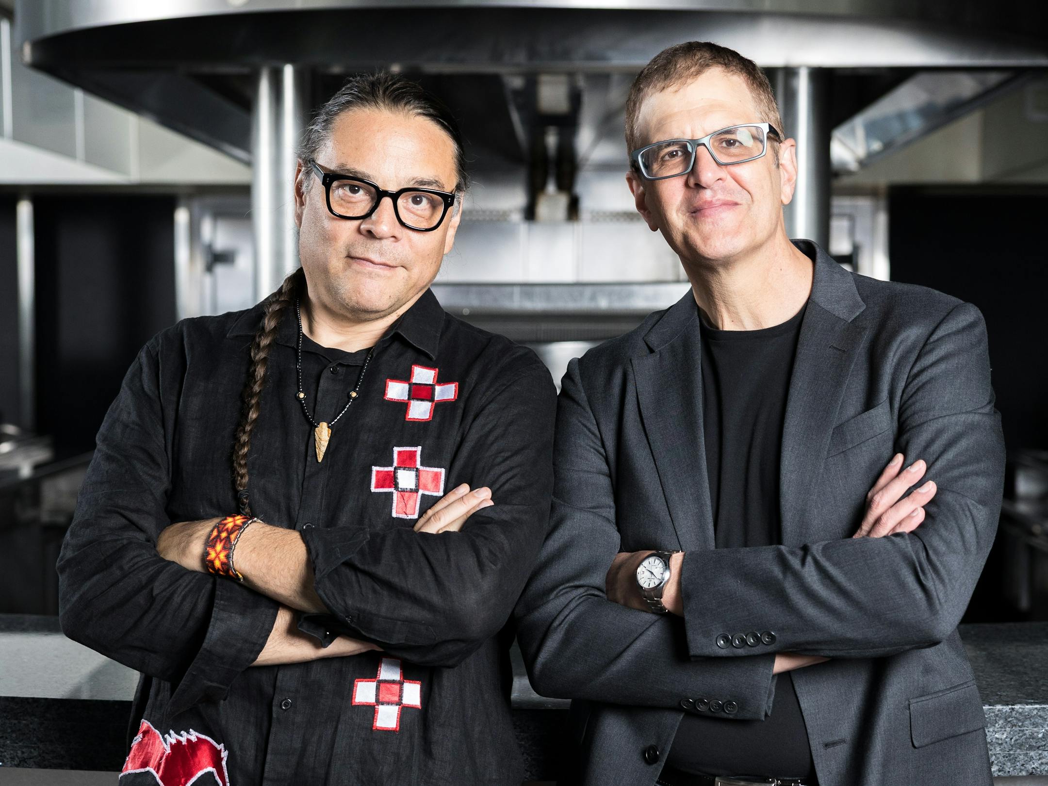 Owamni co-founder Sean Sherman and Guthrie artistic director Joseph Haj standing side by side in a restaurant kitchen