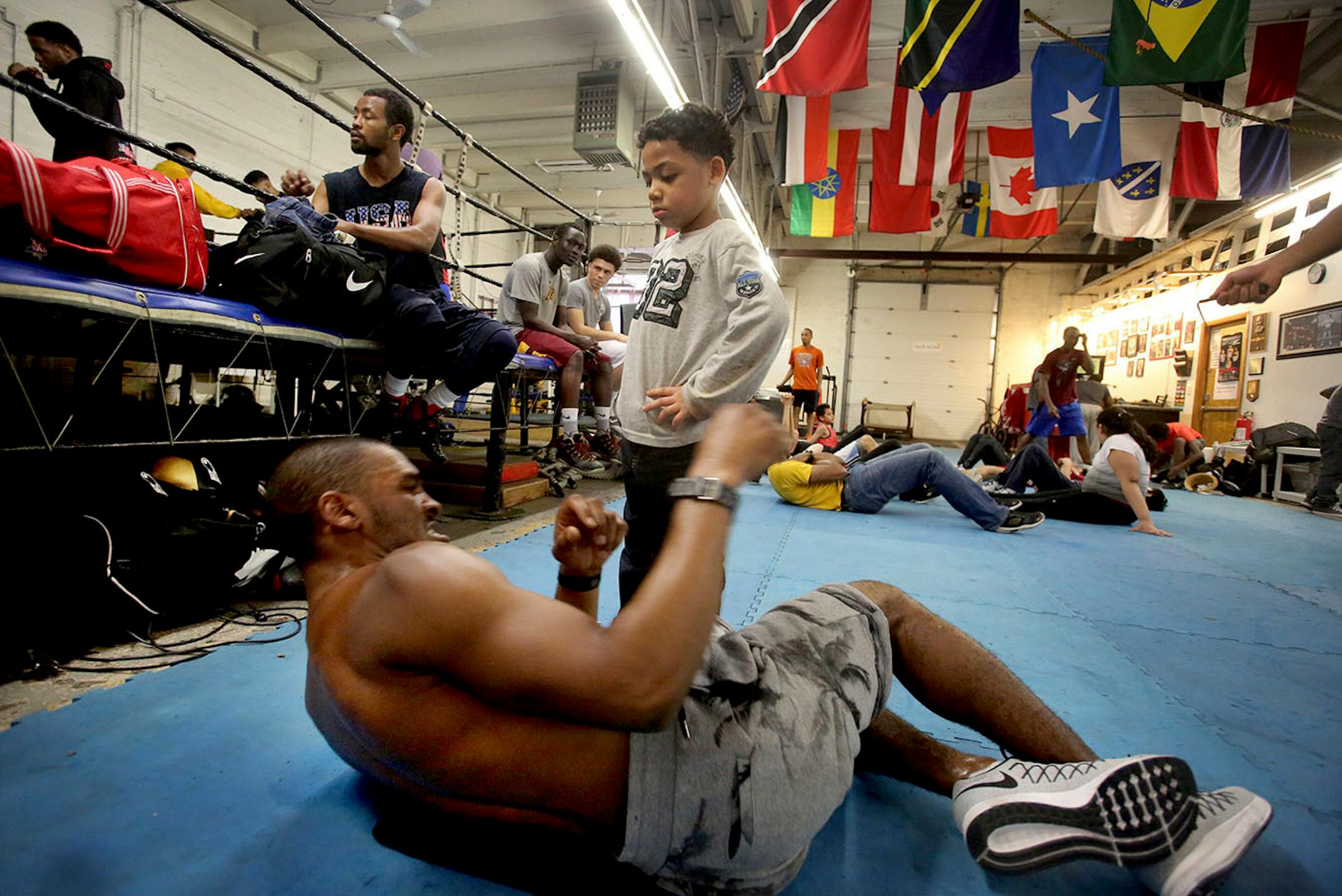 DeParis Frazier, 6, kept an eye on boxer Dwight Lewis as he did abdominal at Circle of Discipline gym in Minneapolis.