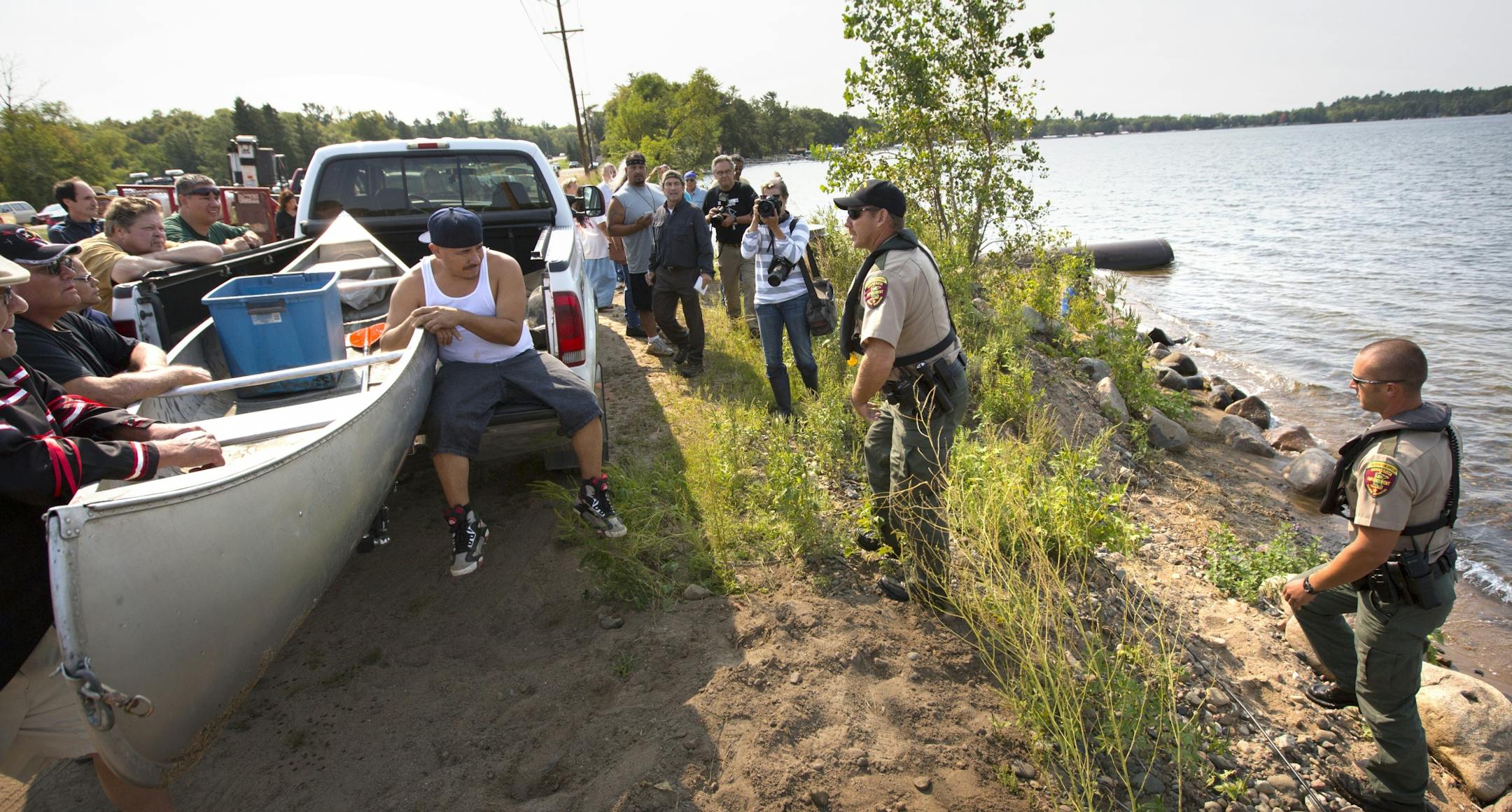 DNR conservation officer Tim Collette (center) approaches a group of Native Americans along the shore of Gull Lake. Looking for two men for Taking Fish by Illegal Methods for setting a gill net on Gull Lake Friday morning.