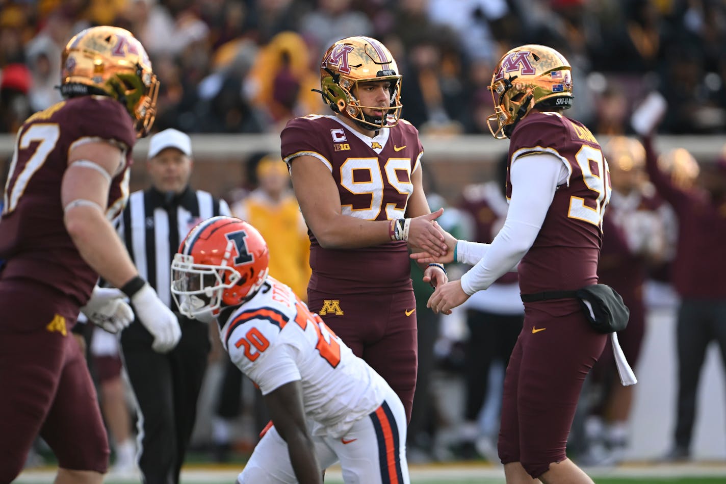 Minnesota Gophers place kicker Dragan Kesich (99) high fives holder Mark Crawford (96) after Kesich kicked a second quarter field goal, giving the Gophers their first lead of the game heading into half time against the Illinois Fighting Illini Saturday, Nov. 4, 2023, at Huntington Bank Stadium in Minneapolis, Minn.. ] AARON LAVINSKY • aaron.lavinsky@startribune.com