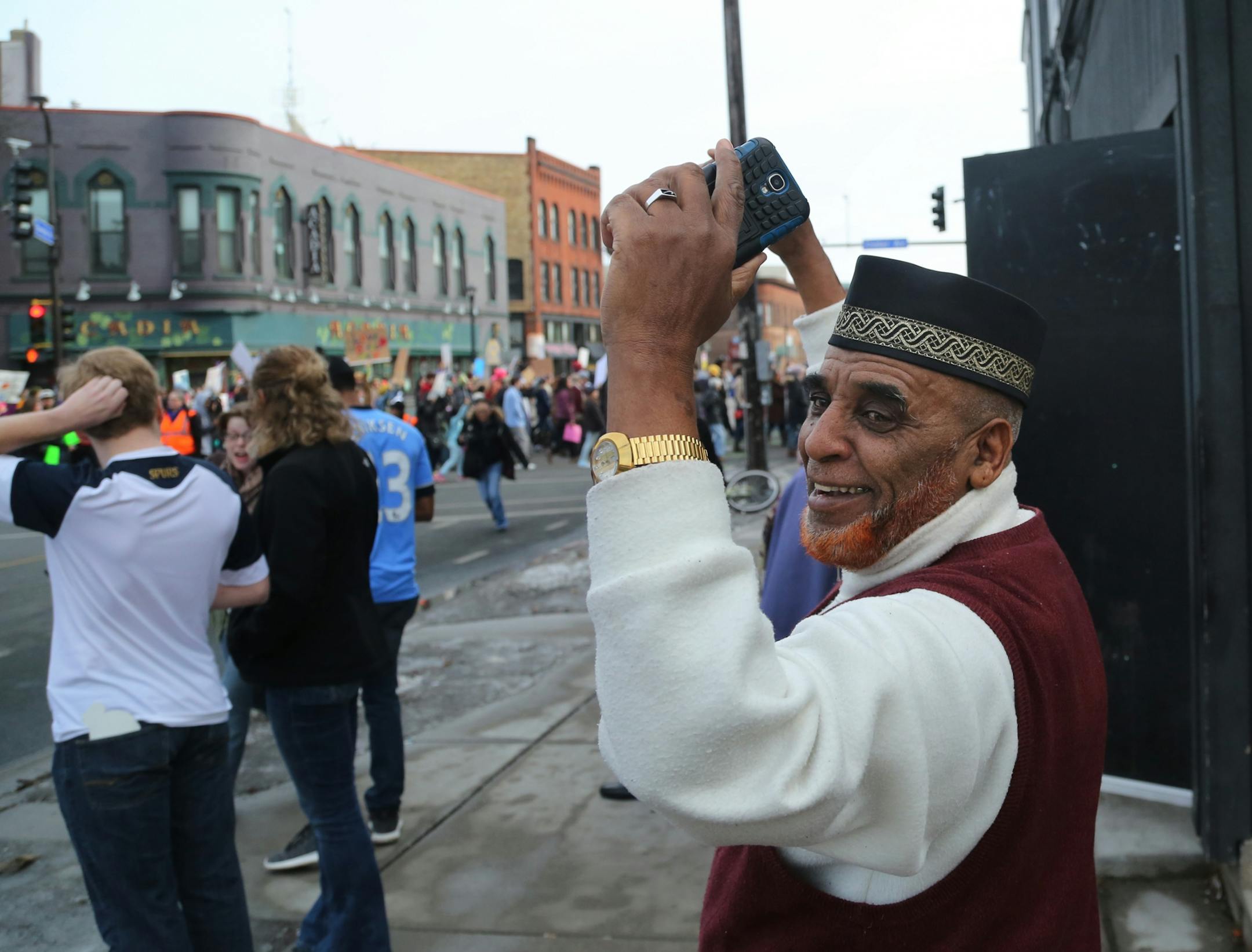 Dube Ganumo, originally from Ethiopia, cheers as The Caravan of Love: A Walk of Love for Immigrants and Refugees comes to the Cedar-Riverside neighborhood.