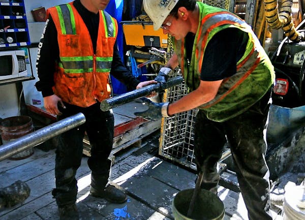 Drillers for Twin Metals, at a site near the Kiwishiwi River, pull a core sample from the drill pipe.